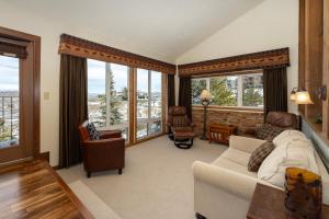 a living room with a couch and chairs and windows at Mountainside Unit B-8 in Granby