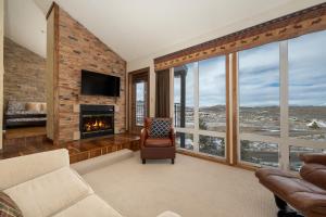 a living room with a fireplace and large windows at Mountainside Unit B-8 in Granby