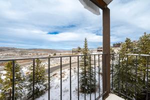 a balcony with snow covered trees and a road at Mountainside Unit B-8 in Granby