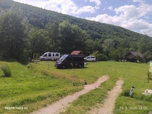 a truck parked in a field next to a mountain at Kamp Suad in Bihać