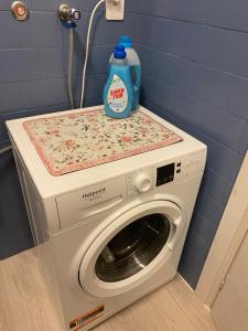a washing machine with a bottle of detergent on top of it at Binario1 Lake View in Lierna