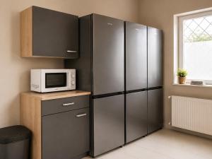 a kitchen with stainless steel refrigerators and a microwave at HK-Vermietung - dezent, ordentlich und preiswert mit allem, was es wirklich braucht in Brieselang