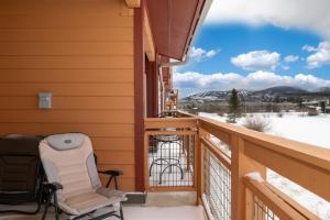 a balcony with chairs and a view of snow covered mountains at Waterside West A206 in Fraser