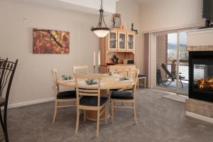 a dining room with a table and a fireplace at Waterside West A206 in Fraser