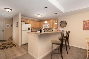 a kitchen with a counter and chairs in a room at Waterside West A206 in Fraser +16 photos