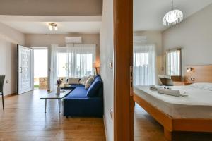 a bedroom with a large bed and a blue couch at Mathios Apartments Falassarna in Falasarna