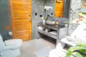 a bathroom with a toilet and a sink and a mirror at Zen Garden Tamarindo - Adults Only in Tamarindo +58 photos