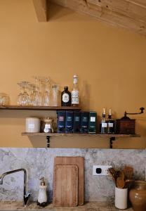 a kitchen counter with a shelf above a sink at Chalet romantique - Jacuzzi privatif - King size in Montignac-Charente