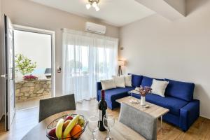a living room with a blue couch and a table at Mathios Apartments Falassarna in Falasarna