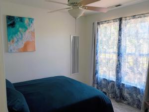 a bedroom with a blue bed and a window at Beach Hoppers' Hideaway in Cape Charles