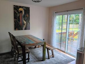 a dining room with a wooden table and a window at Beach Hoppers' Hideaway in Cape Charles
