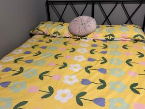a bed with a yellow comforter with a pink pillow on it at 40 kennett gardens in Gloucester