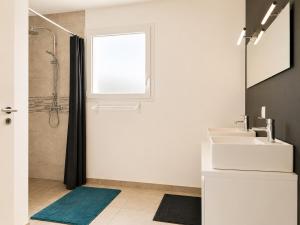 a white bathroom with a sink and a window at Maison Jean Moulin in Saint-Augustin