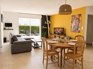 a living room with a table and a couch at Maison Jean Moulin in Saint-Augustin