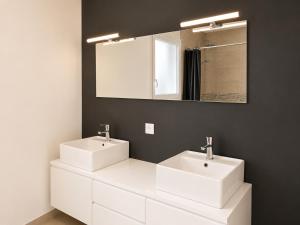 a bathroom with two white sinks and a mirror at Maison Jean Moulin in Saint-Augustin