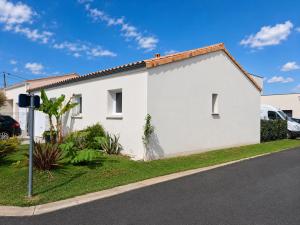 a white house on the side of a street at Maison Jean Moulin in Saint-Augustin