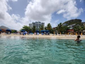 a woman in the water in front of a beach at Beachfront Condo in Simpson Bay, SXM - 2BR 2BA in Simpson Bay