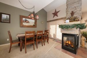 ein Esszimmer mit Kamin, Tisch und Stühlen in der Unterkunft Waterside West E206 in Fraser