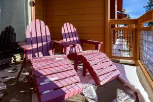 ein Paar rosa Stühle auf einer Veranda in der Unterkunft Waterside West E206 in Fraser