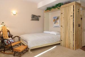 ein Schlafzimmer mit einem Bett und einem Holzschrank in der Unterkunft Waterside West E206 in Fraser + 15 Fotos