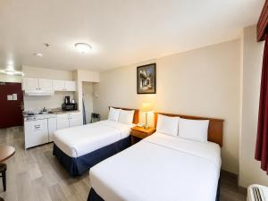 a hotel room with two beds and a kitchen at Ace Inn in Fort McMurray +17 photos