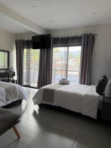 ein Schlafzimmer mit zwei Betten und einem großen Fenster in der Unterkunft Hotel HS Confort in Orizaba