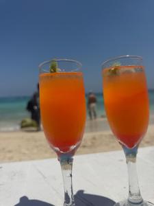 two wine glasses sitting on a table near the beach at Zulu beach in Cartagena de Indias