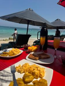 a table with two plates of food on a beach at Zulu beach in Cartagena de Indias