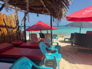 a beach with chairs and tables and umbrellas on the beach at Zulu beach in Cartagena de Indias