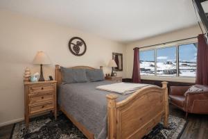 a bedroom with a bed and a chair and a window at Summit Unit 1303 in Granby +21 photos