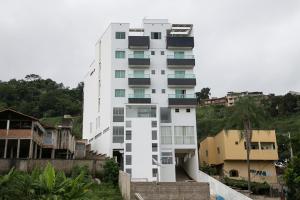 a white building with balconies on the side of it at Peçanha Grande Hotel in Peçanha