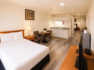 a hotel room with a bed and a kitchen at Ace Inn in Fort McMurray