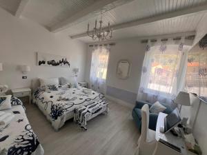 a bedroom with two beds and a chair and window at LE CINQUE VELE ***** Cinque Terre in Monterosso al Mare