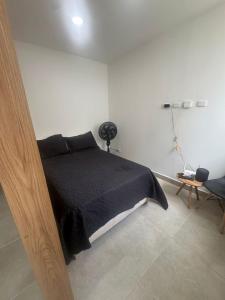 a bedroom with a black bed in a white room at Praseo in Serena del Mar