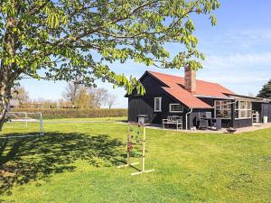 a black house with a playground in front of it at 6 person holiday home in Vinderup-By Traum in Vinderup