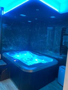 a jacuzzi tub in a room with blue lights at CK Suite & Spa - Jacuzzi Privatif - Reims in Reims +29 photos