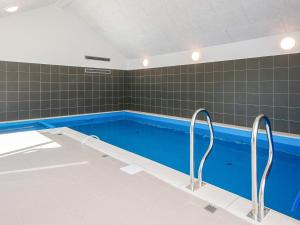 a swimming pool with two faucets in a room at 5 star holiday home in Jerup in Jerup