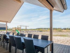 a table and chairs on a deck with a playground at 5 star holiday home in Jerup in Jerup