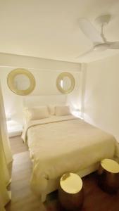 a bedroom with a large white bed with two mirrors at La loge in Marigot