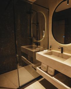 ein Badezimmer mit Waschbecken und Spiegel in der Unterkunft Noir Hotel in Gjakove + 23 Fotos
