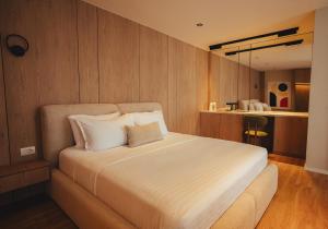 Ein Schlafzimmer mit einem großen weißen Bett und Holzwänden in der Unterkunft Noir Hotel in Gjakove
