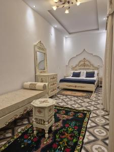 a bedroom with two beds and a mirror and a rug at dar Beya in Kairouan