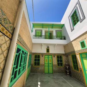 a building with green doors and a balcony at dar Beya in Kairouan