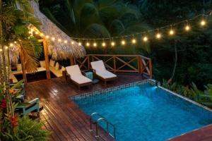 a swimming pool on a wooden deck with lights at Central Hotel Bocas del Toro in Valle de Agua