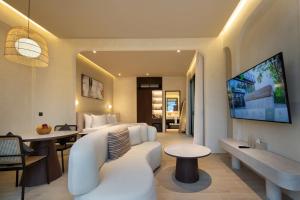 a hotel room with a couch and a living room at The Lario Collection - A Wellness Resort in Seminyak