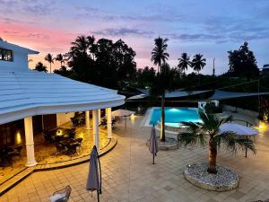 a resort with a pool and tables and umbrellas at La Pala Suites in Las Terrenas
