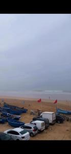 a group of parked cars and boats on the beach at Sharing is caring Taghazout in Taghazout