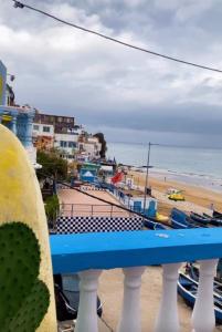 a blue bench in front of a beach at Sharing is caring Taghazout in Taghazout