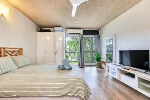 a bedroom with a bed and a flat screen tv at Beachfront Bliss Studio Apt on the Foreshore in Nightcliff
