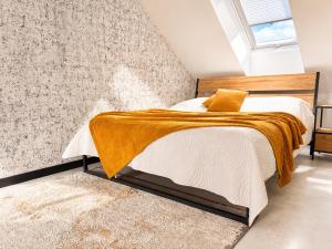 a bedroom with a bed with a brown blanket at Apartament Niebo przy plaży ROYAL APARTS OSTRÓDA in Ostróda